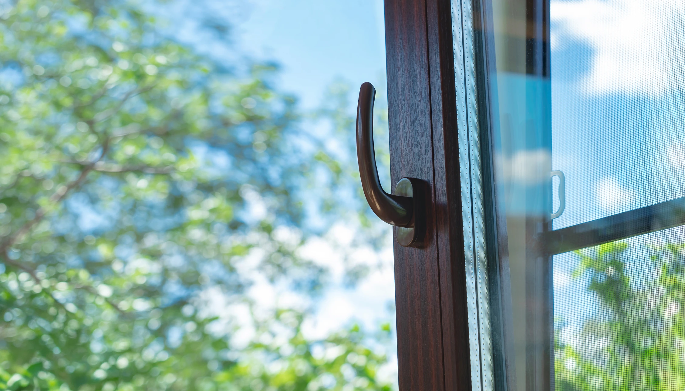 Un serrurier répare une serrure de porte d'entrée en bois vernis