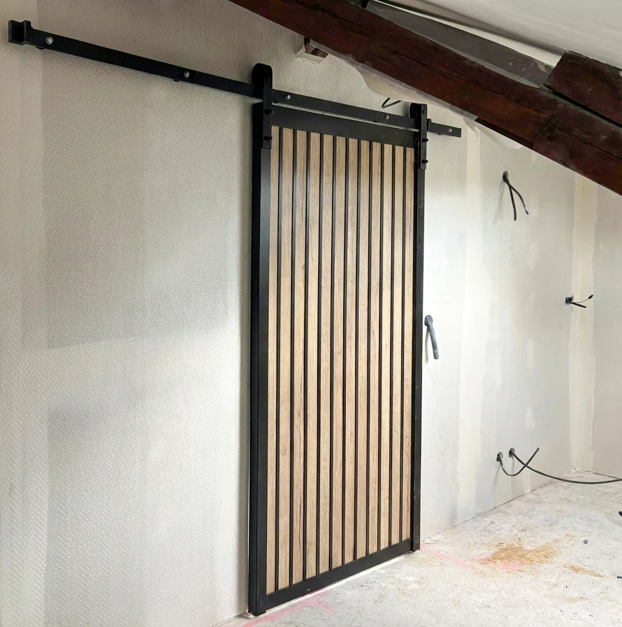 Intérieur en rénovation, mur enduit beige avec une fenêtre à soufflet (oscillo-battante) à châssis PVC blanc, format horizontal panoramique