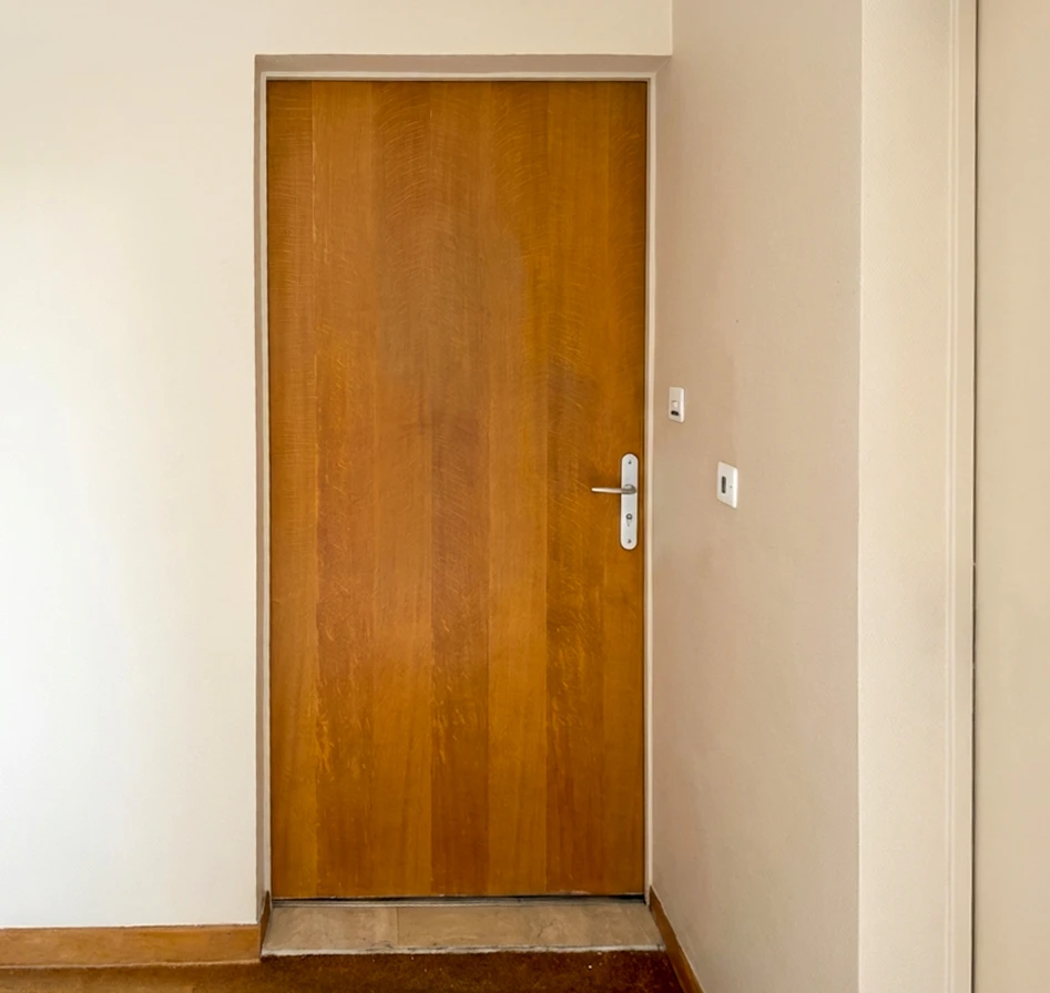 Intérieur en rénovation, mur enduit beige avec une fenêtre à soufflet (oscillo-battante) à châssis PVC blanc, format horizontal panoramique