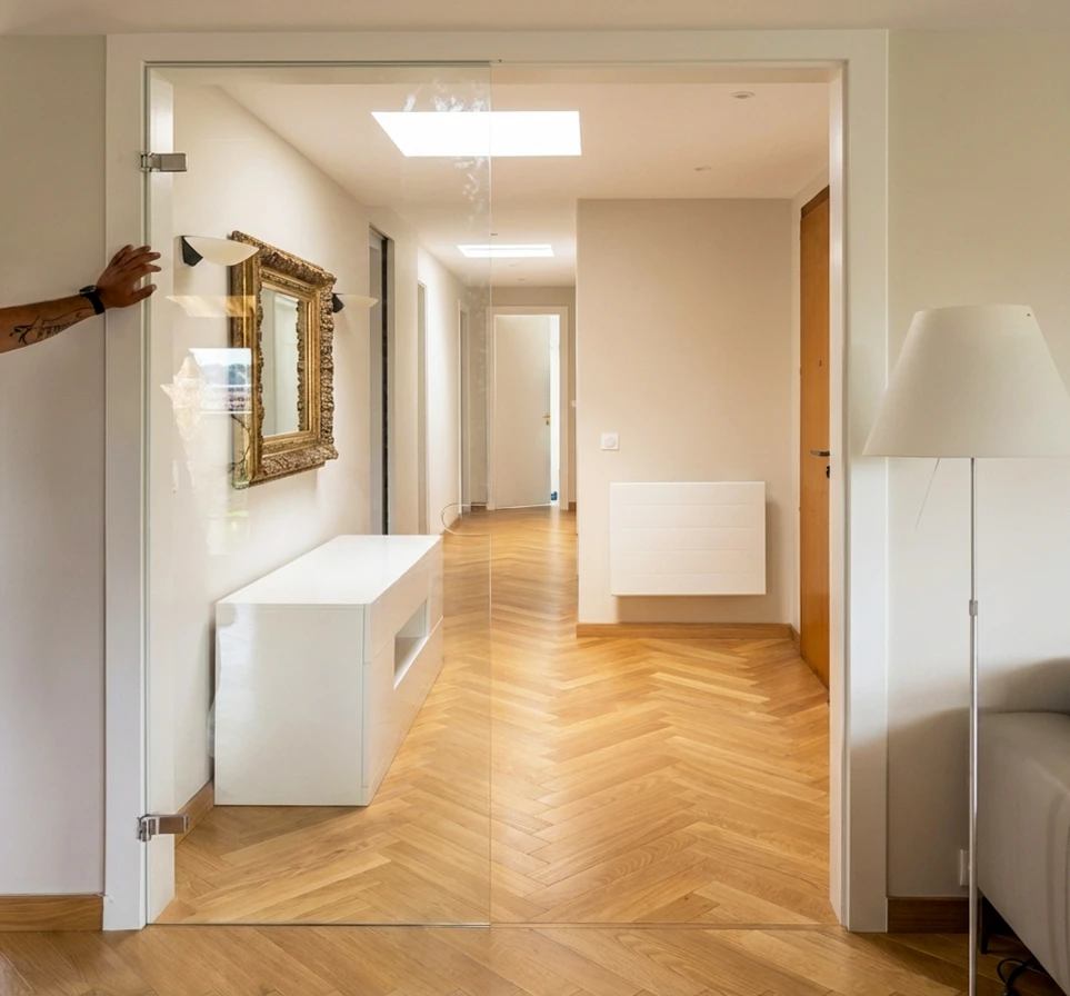 Intérieur en rénovation, mur enduit beige avec une fenêtre à soufflet (oscillo-battante) à châssis PVC blanc, format horizontal panoramique